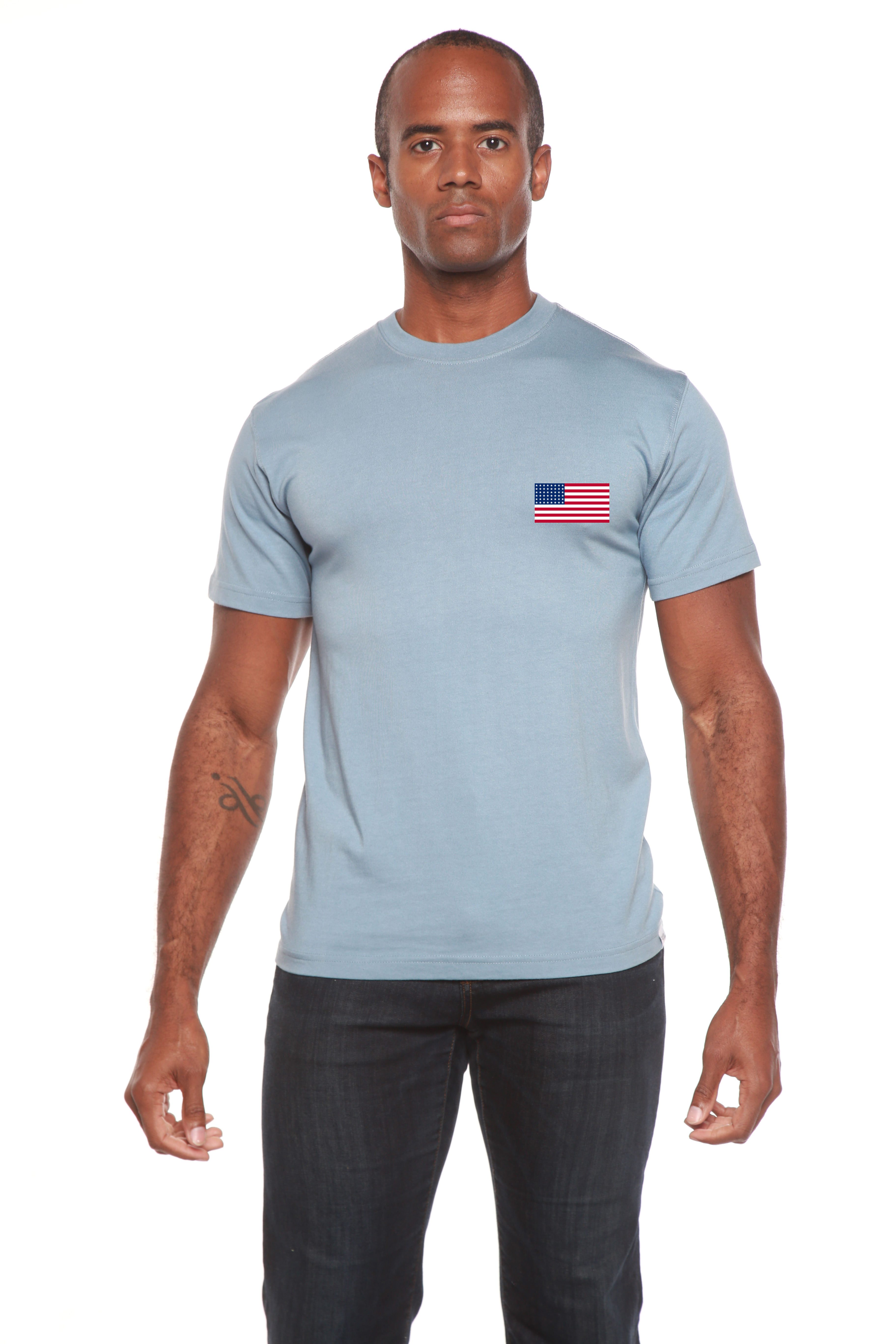 Man wearing a light blue t-shirt with an American flag patch on a white background