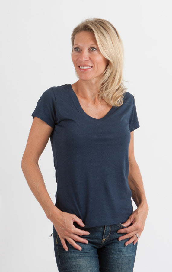 Woman wearing a navy blue t-shirt and jeans on a white background