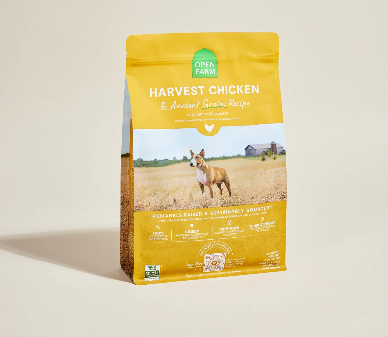A bag of Open Farm Harvest Chicken & Ancient Grains Recipe dog food, featuring a bright yellow packaging with a photo of a dog in a field, set against a warm beige background.