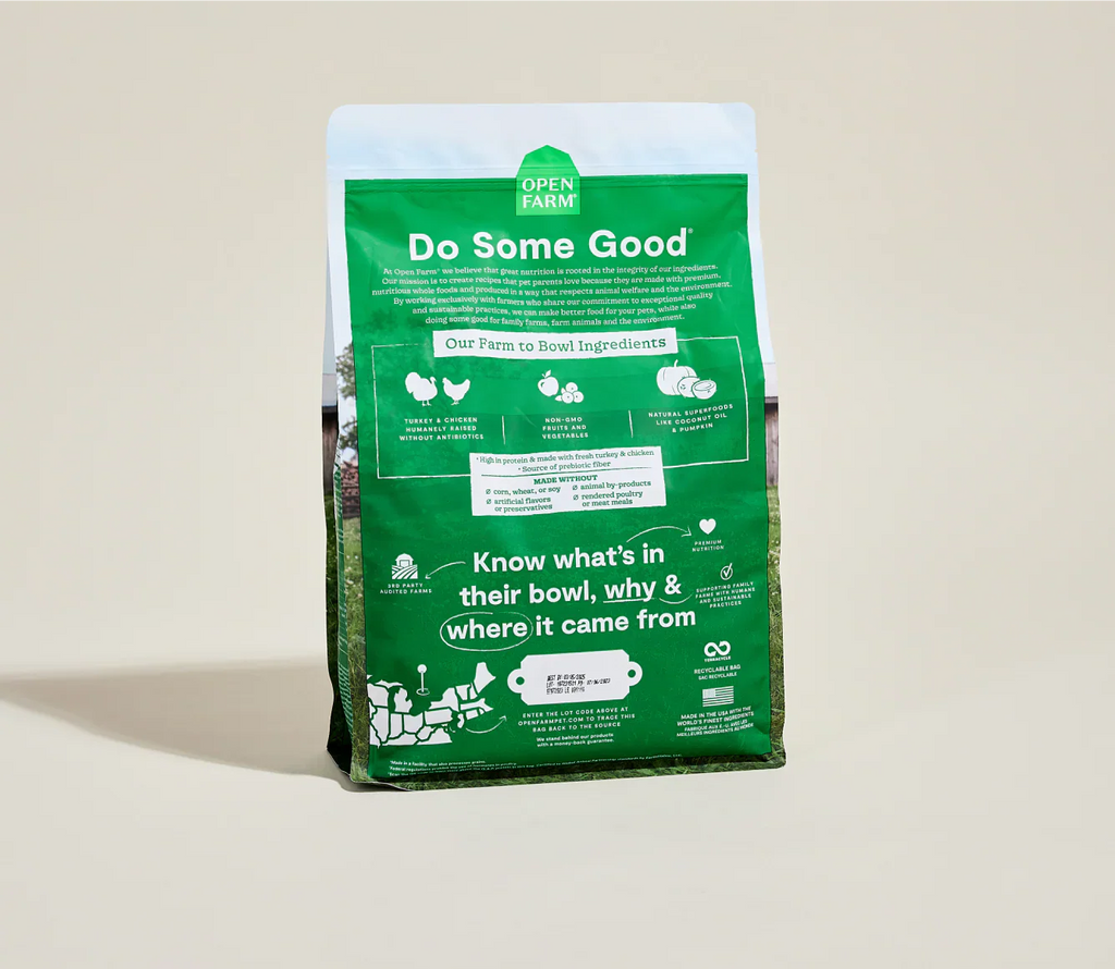 Green bag of Open Farm pet food on a beige background