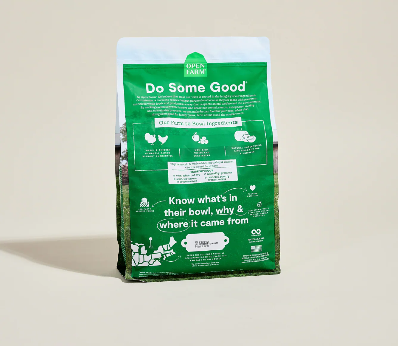 Green bag of Open Farm pet food on a beige background