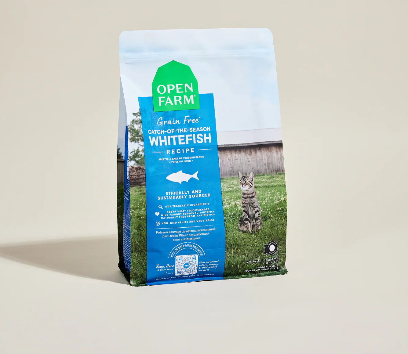 Bag of Open Farm cat food with a cat on a grassy field