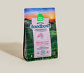 A bag of Open Farm Good Bowl dog food, Wild-Caught Salmon & Brown Rice Recipe, standing upright on a light beige background. The packaging features a scenic landscape of green fields under a sunset sky, with a central white panel displaying the brand name.