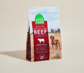 Open Farm grain-free grass-fed beef recipe dog food package on a beige background