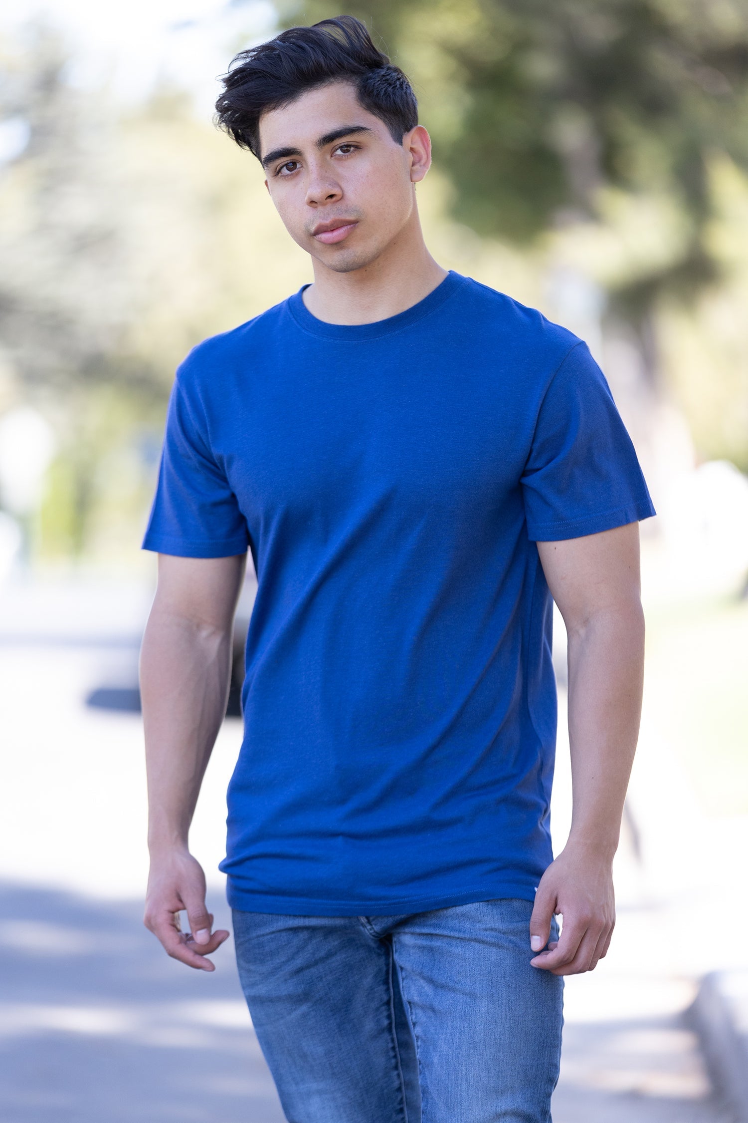 Person wearing a blue t-shirt and jeans outdoors