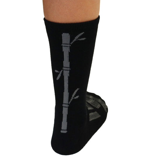 Black sock with bamboo design worn by a person on a white background