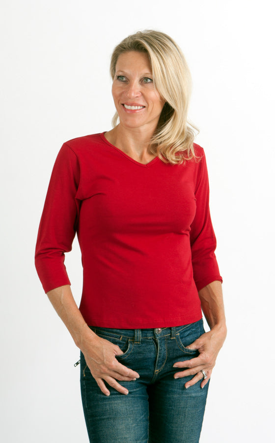 Woman wearing a red sweater and blue jeans on a white background