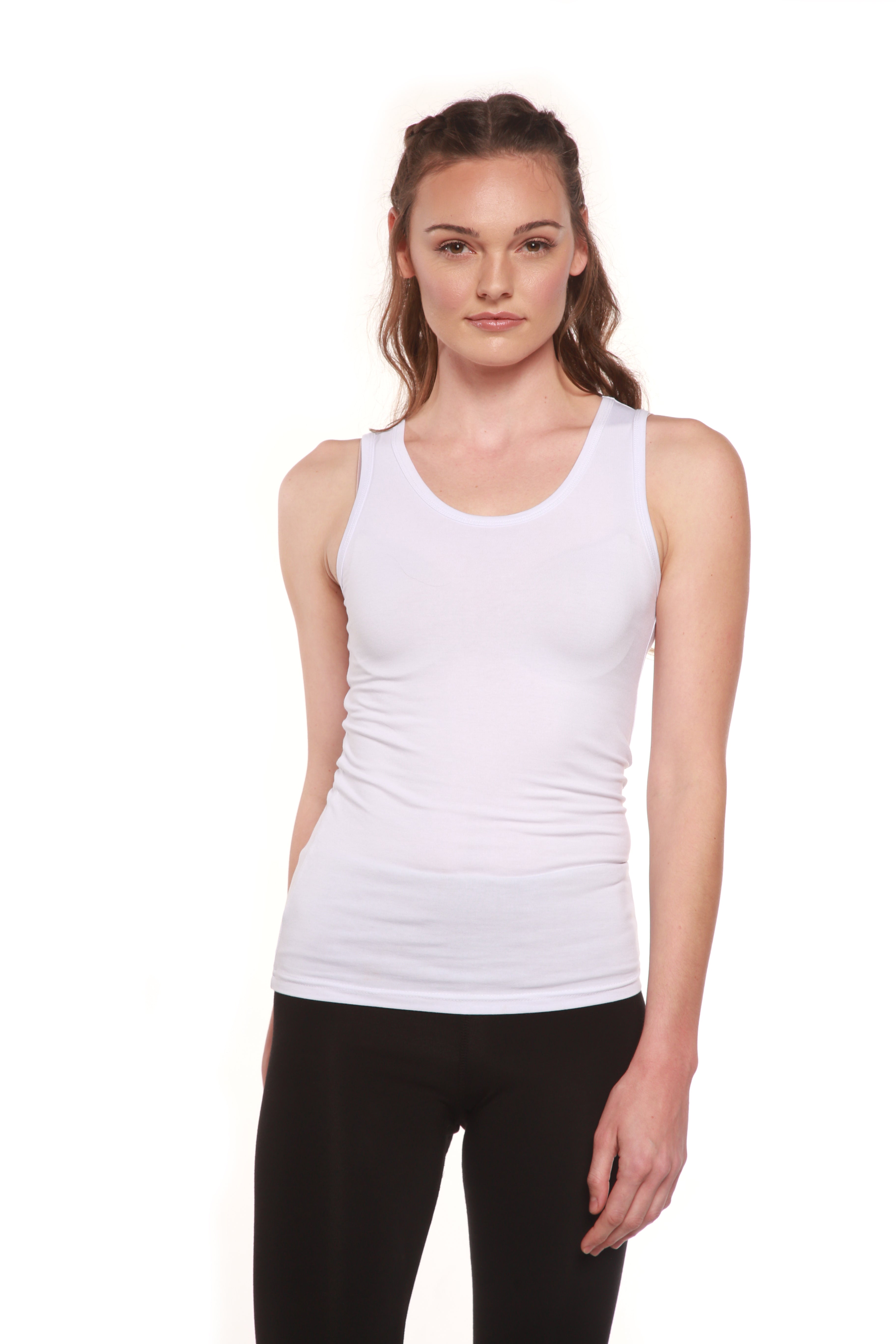 Woman wearing a white tank top and black leggings on a white background
