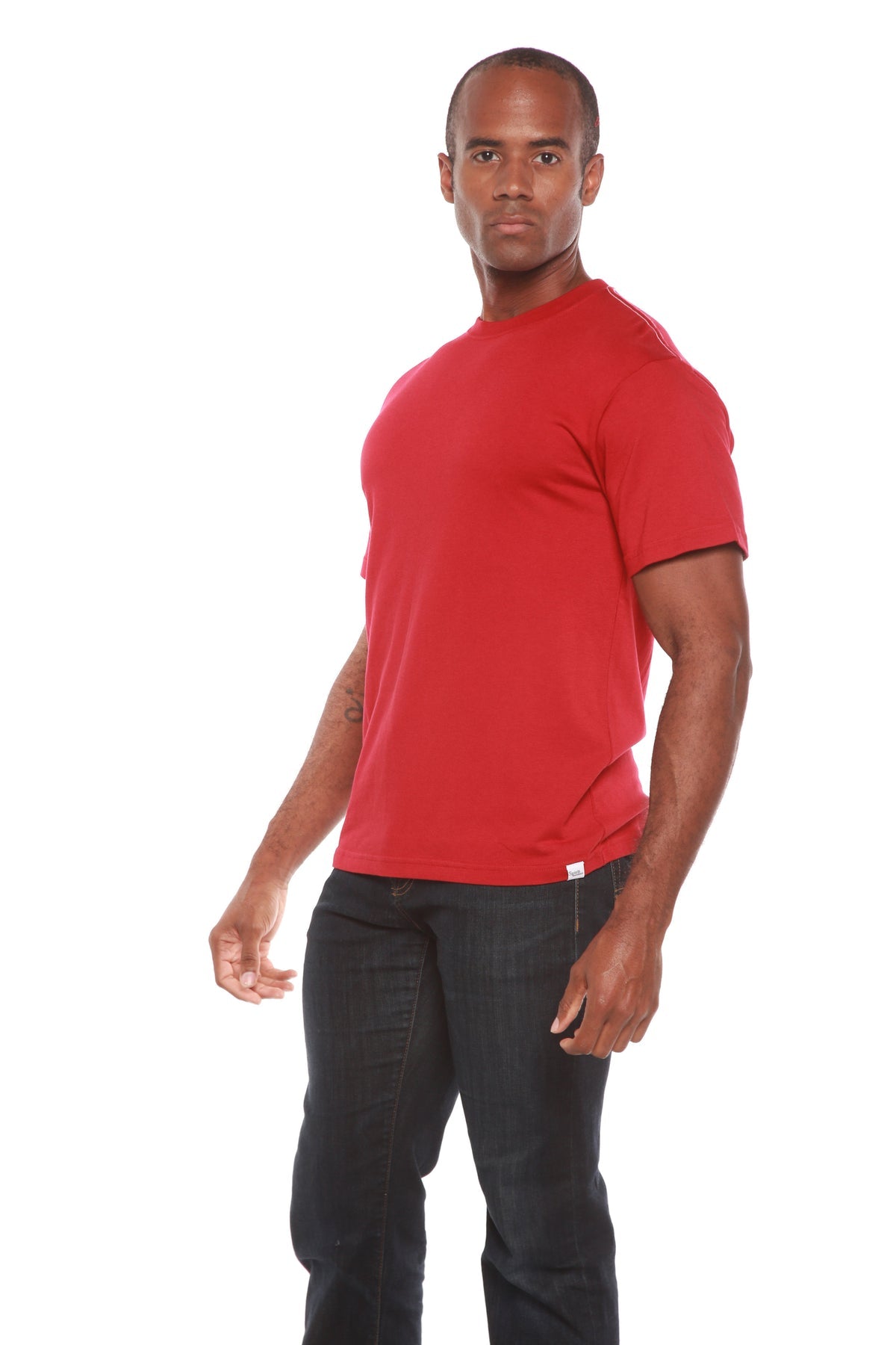 Man wearing a red t-shirt and dark pants on a white background