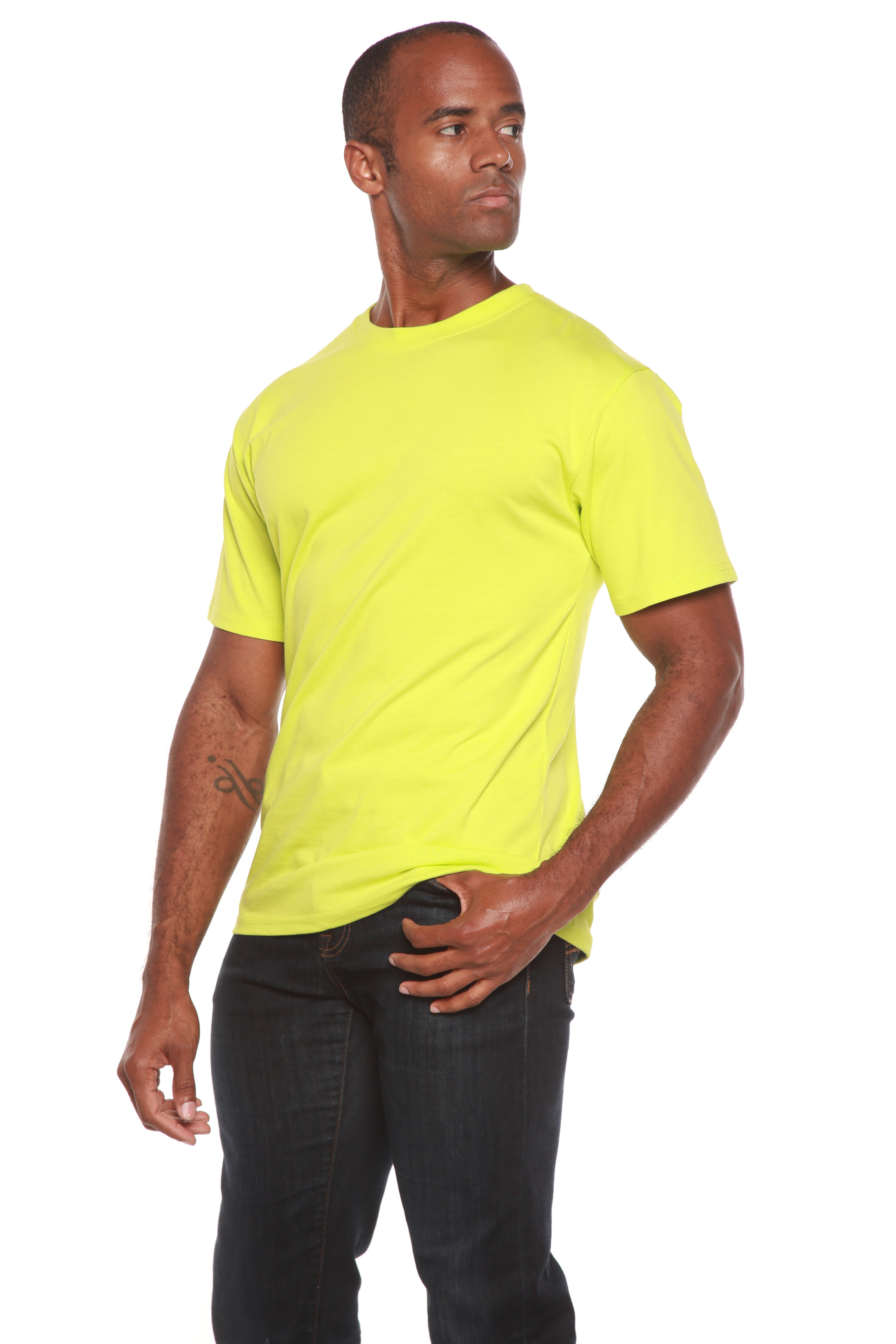 Man wearing a bright yellow t-shirt and dark jeans on a white background
