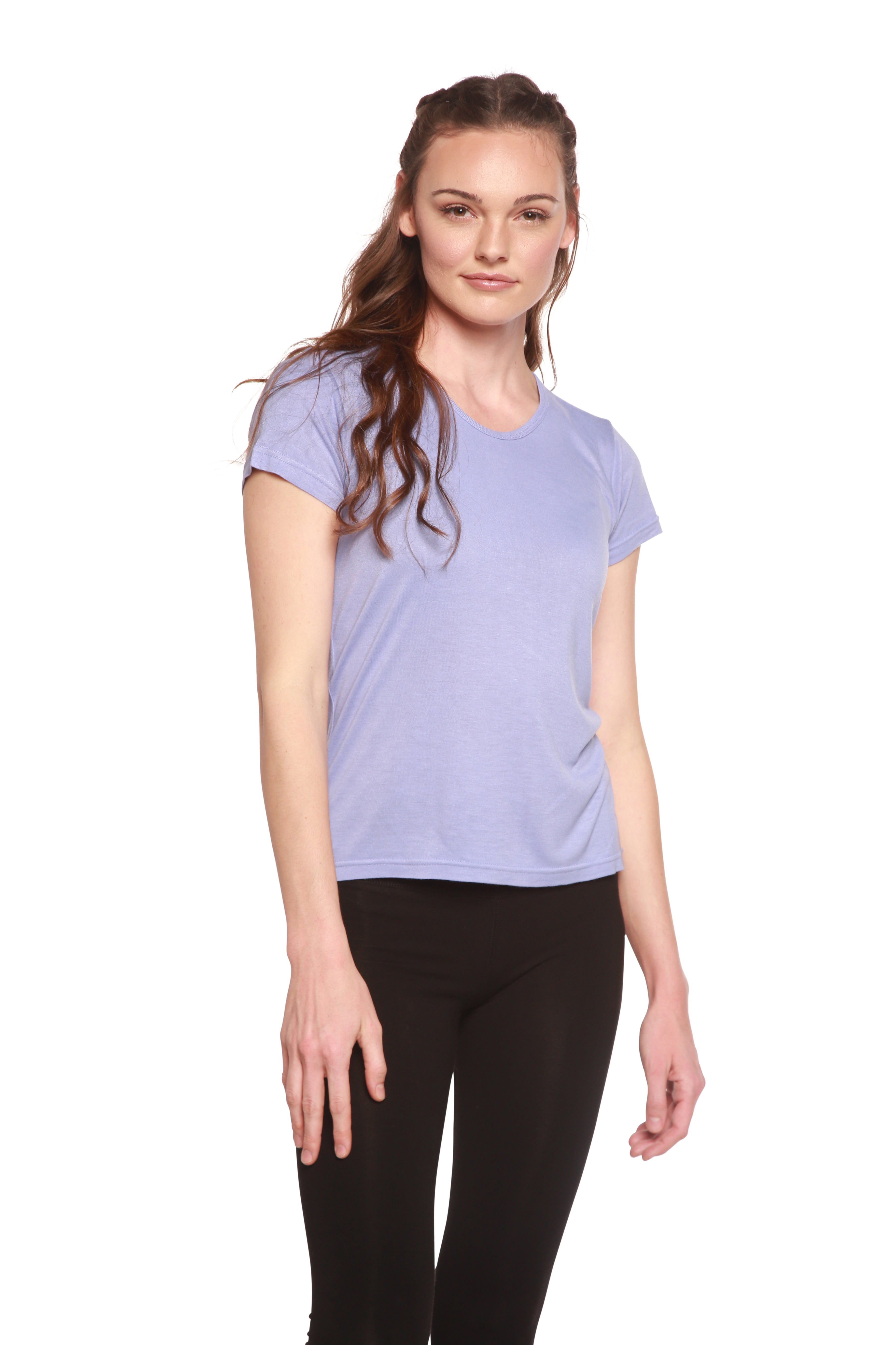 Woman wearing a light purple t-shirt and black leggings on a white background