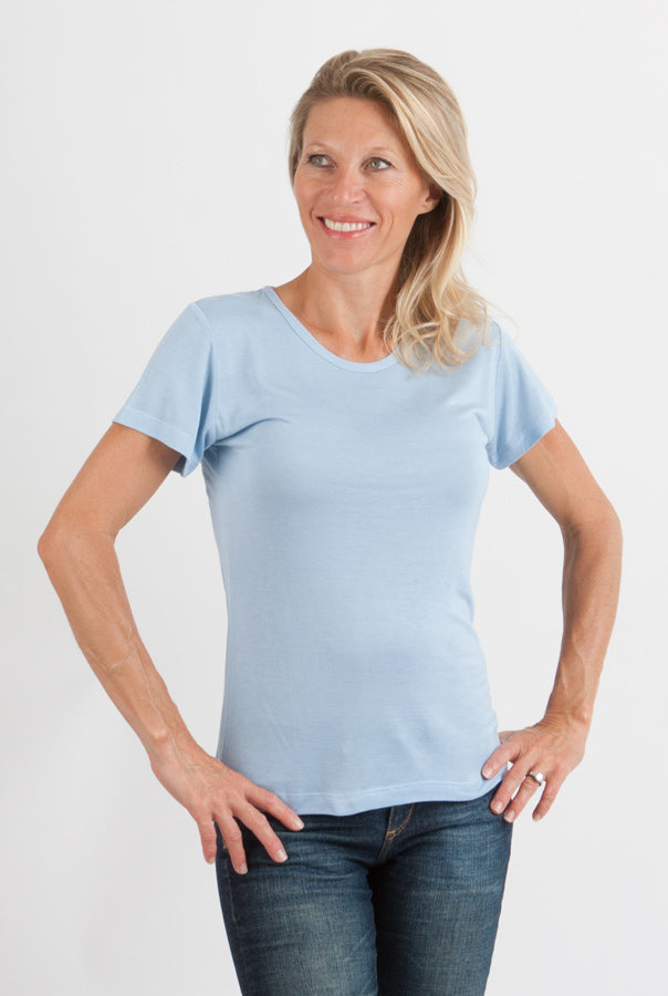 Woman wearing a light blue t-shirt and jeans on a white background