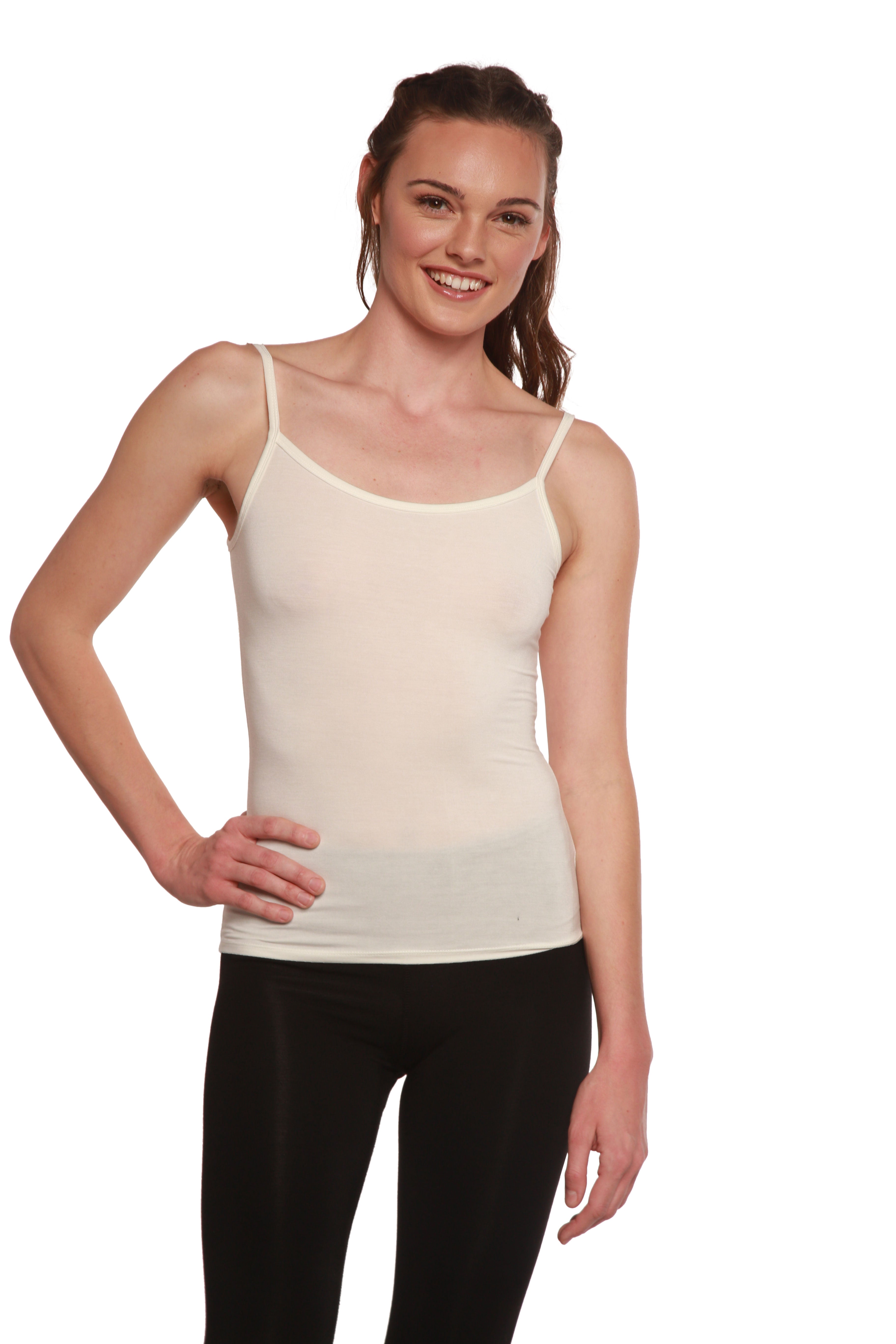 Woman wearing a beige camisole and black pants on a white background