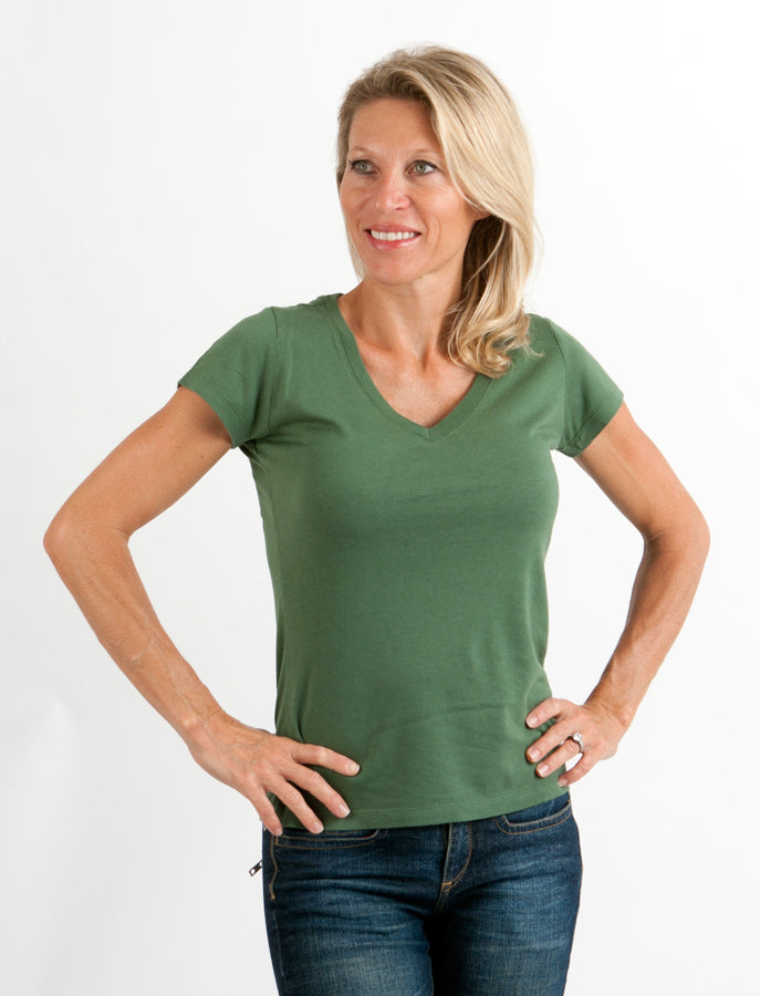 Woman wearing a green t-shirt and blue jeans on a white background