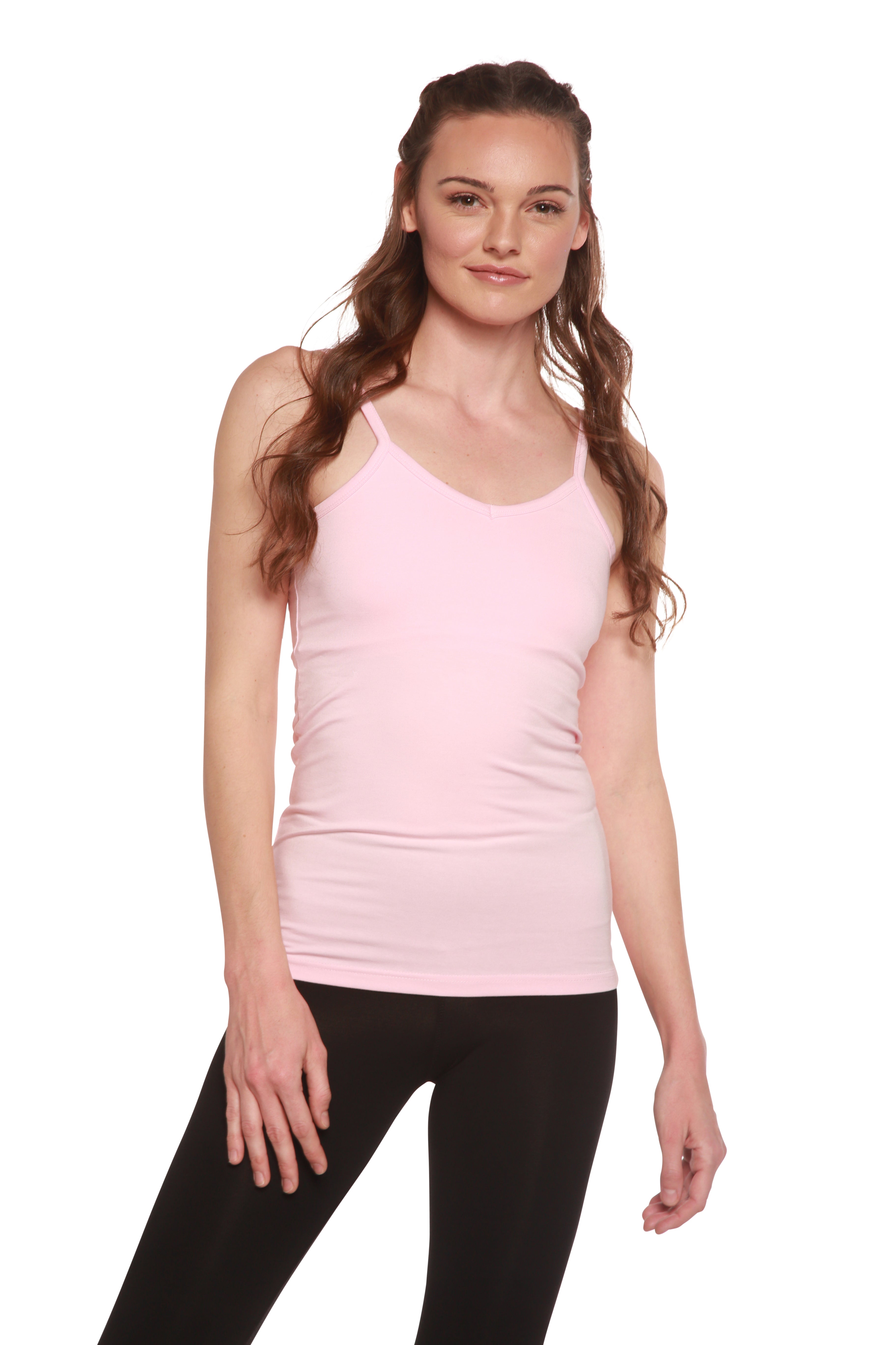 Woman wearing a pink tank top and black leggings on a white background