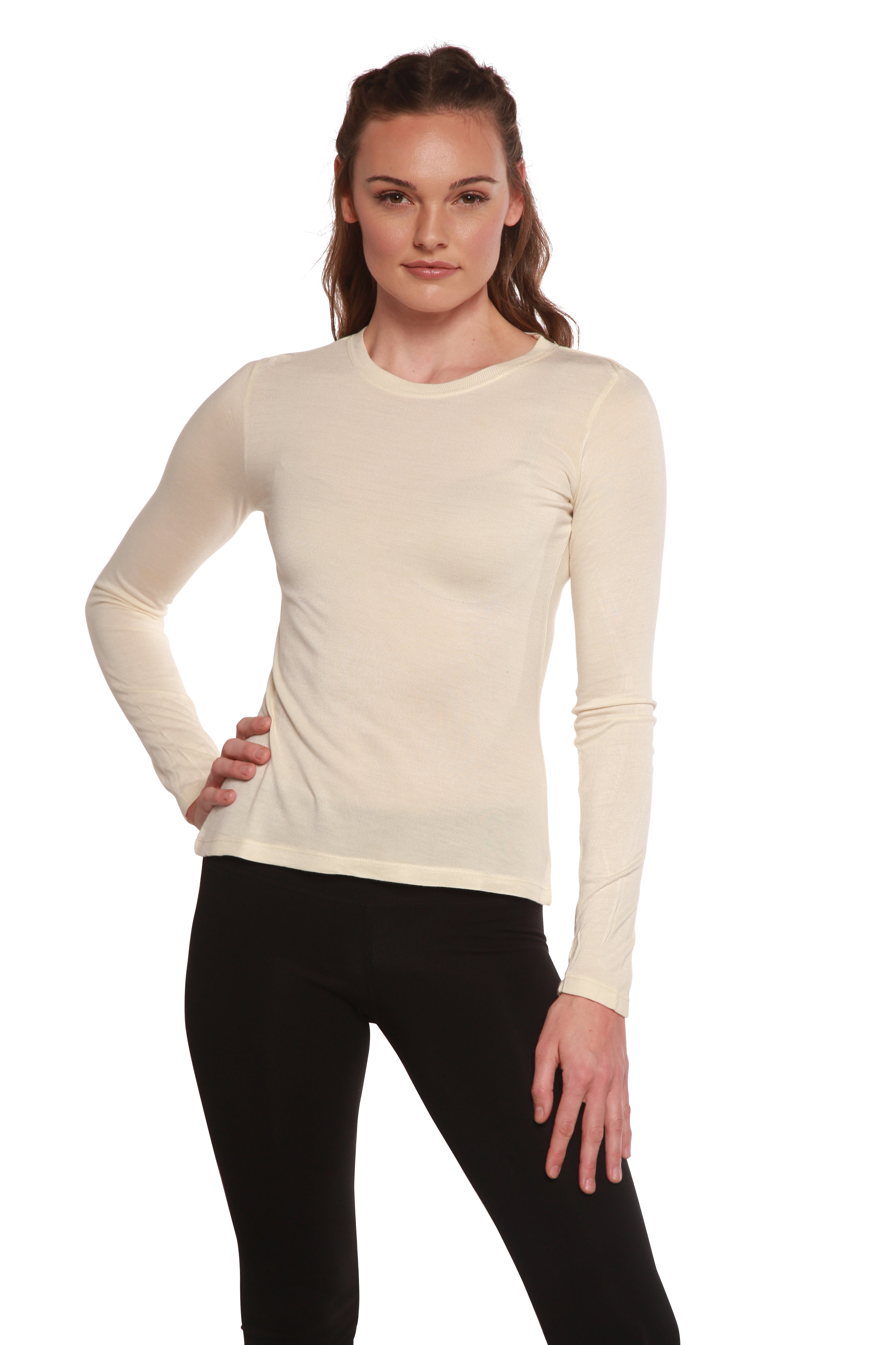 Woman wearing a beige long-sleeve top and black pants on a white background